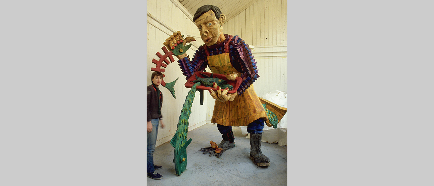 Title: Vincent the Fisherman. Exhibited at the Liverpool International Garden Festival in 1984. Wood Sculpture by Michael Winstone